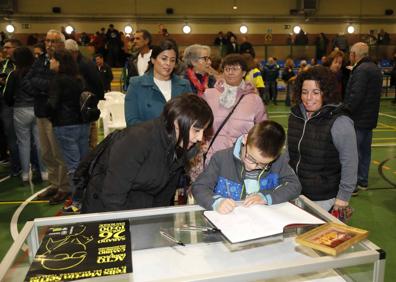 Imagen secundaria 1 - Muestra fotográfica durante el homenaje, firmas de agradecimiento en el libro y Ángela, una de las monitoras del club