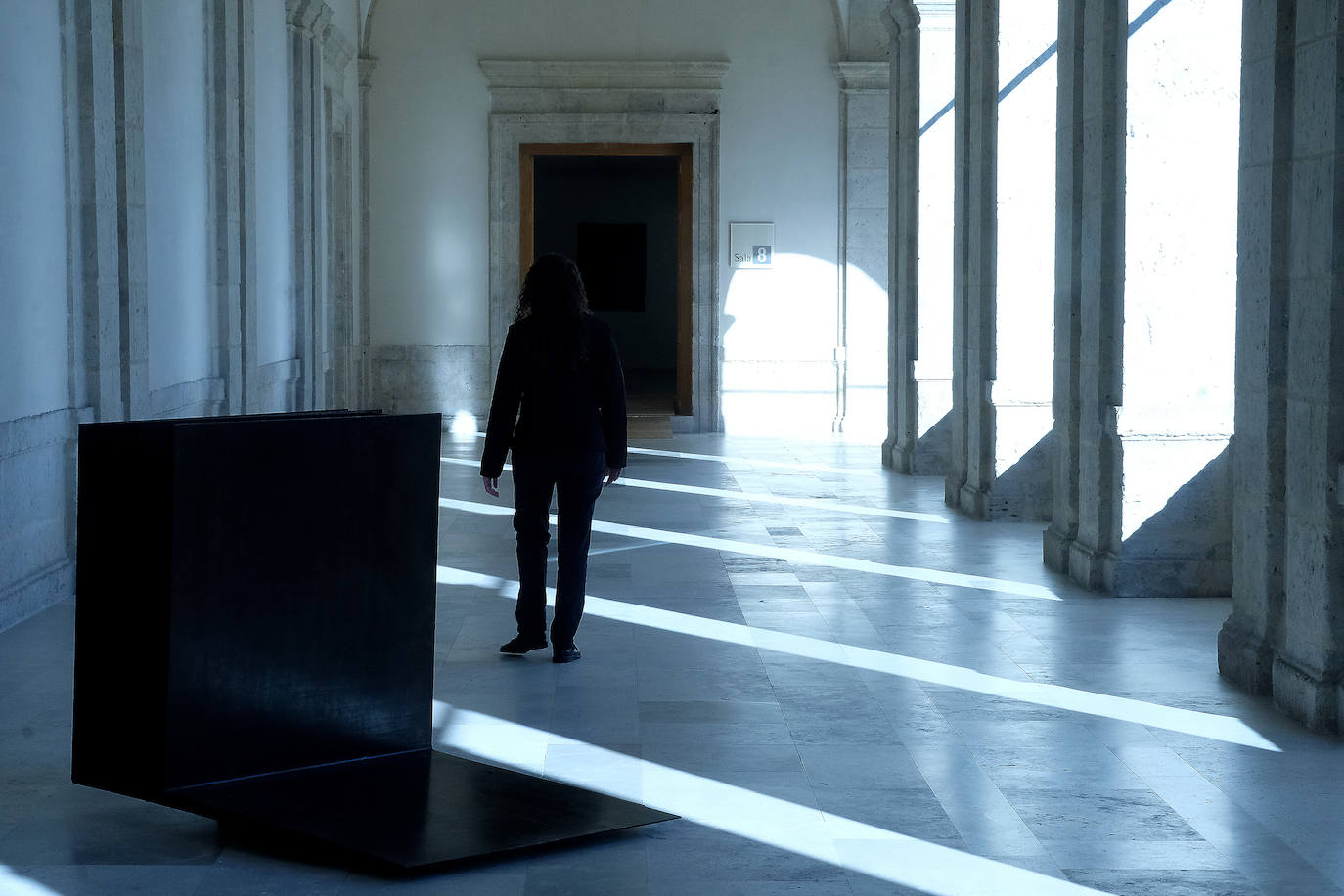 Una mujer observa uno de los cuadros de la exposición.