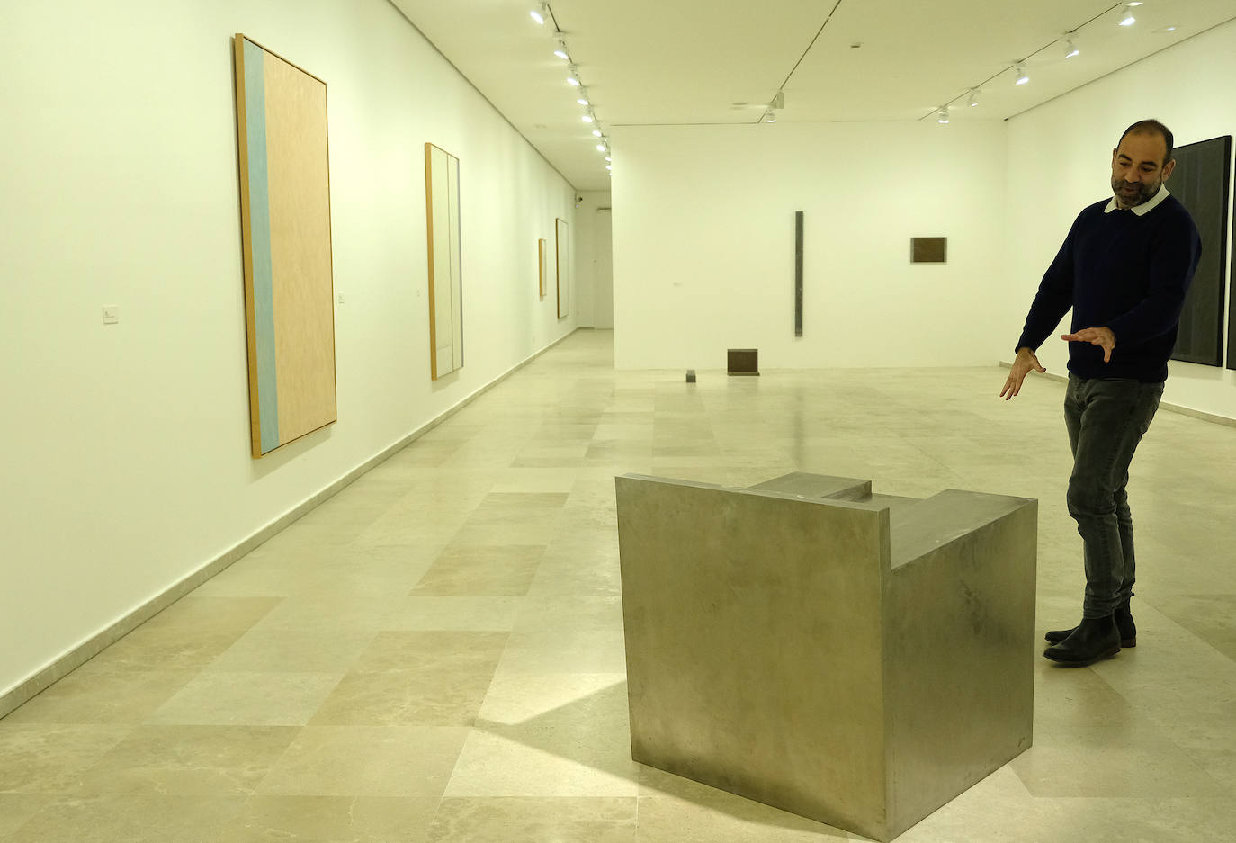 Una mujer observa uno de los cuadros de la exposición.