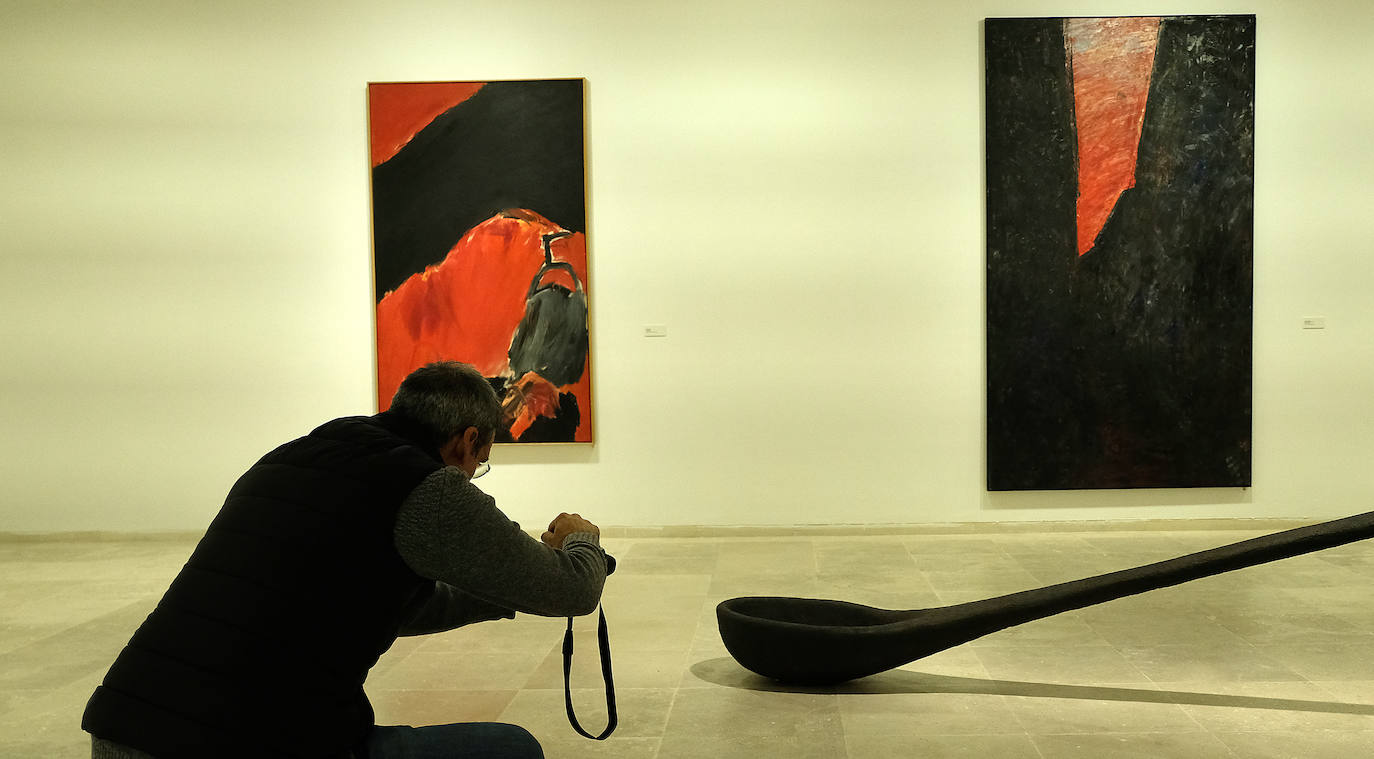 Una mujer observa uno de los cuadros de la exposición.