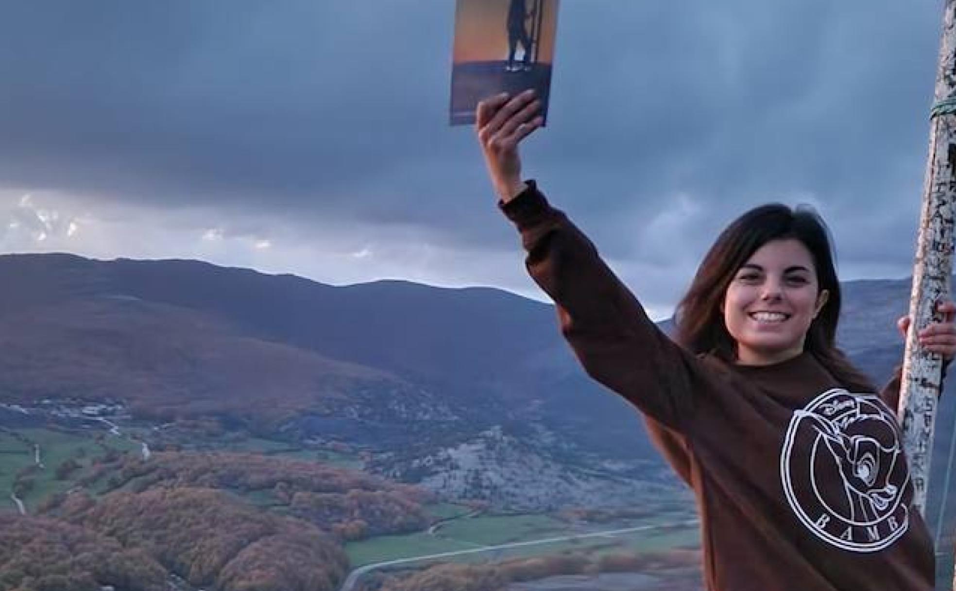 Esther Olivares en la Cruz de Velilla con su libro en la mano.