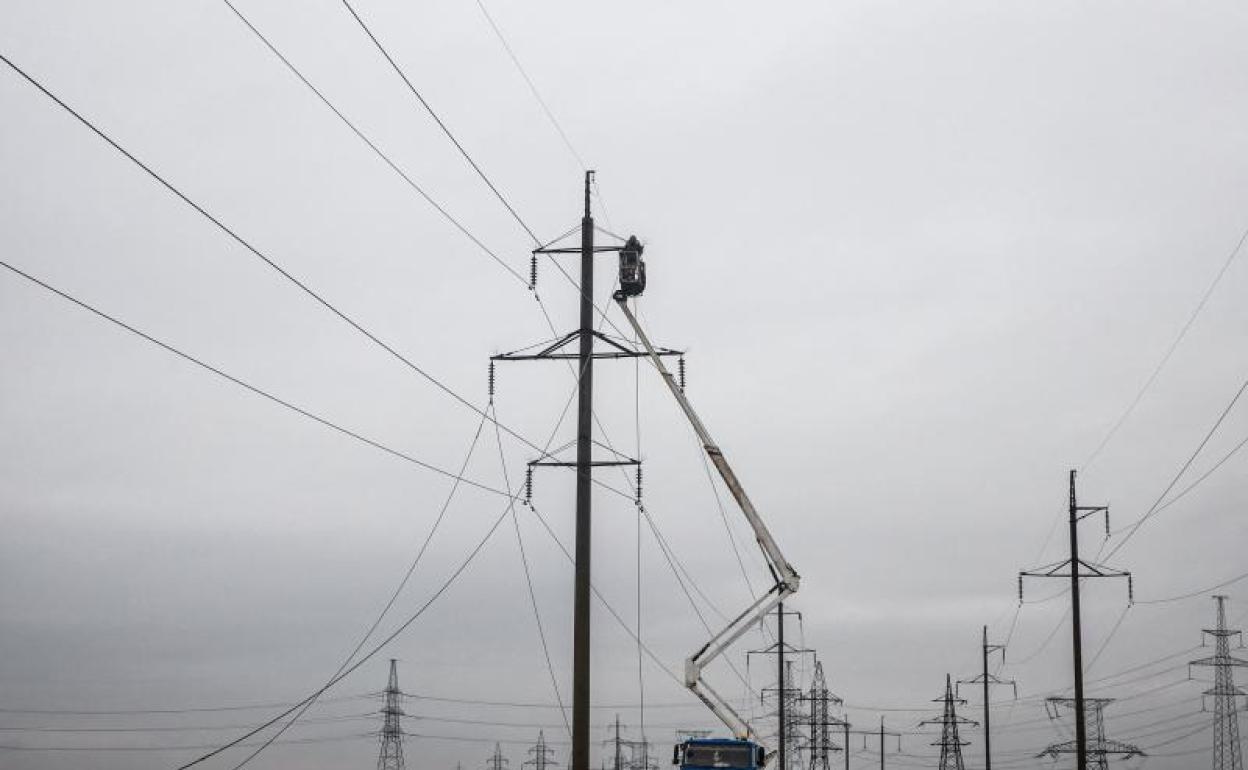 Trabajadores reparan líneas eléctricas de alto voltaje dañadas por los ataques rusos en Odesa. 