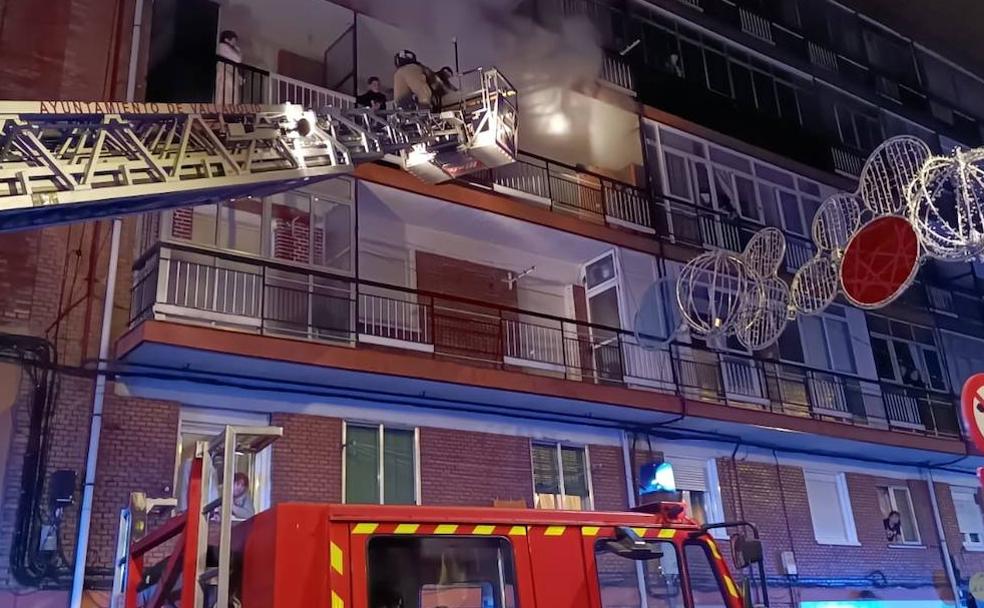 Los bomberos rescatan a través de una escala a vecinos de una de las viviendas afectadas por el humo. 