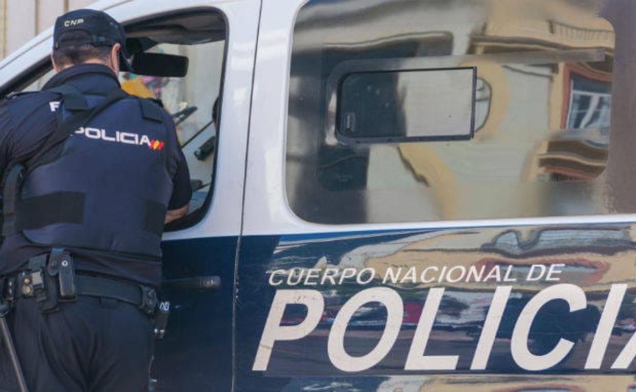 Un agente de la Policía Nacional junto a un furgón del cuerpo. 