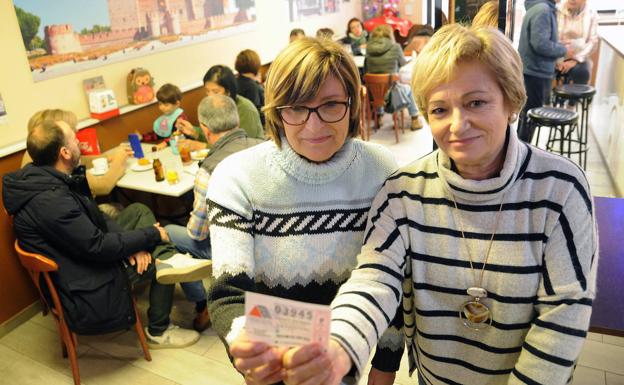 Merche y Flor González Espinosa, de la administración, muestran el número agraciado en el Bar Zamorano.