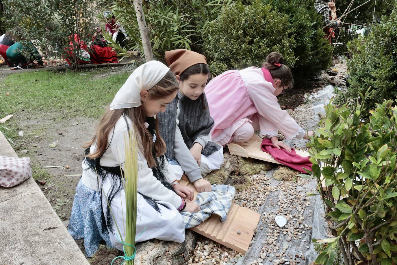 Ancianos observan a los alumnos interpretar el belén viviente.