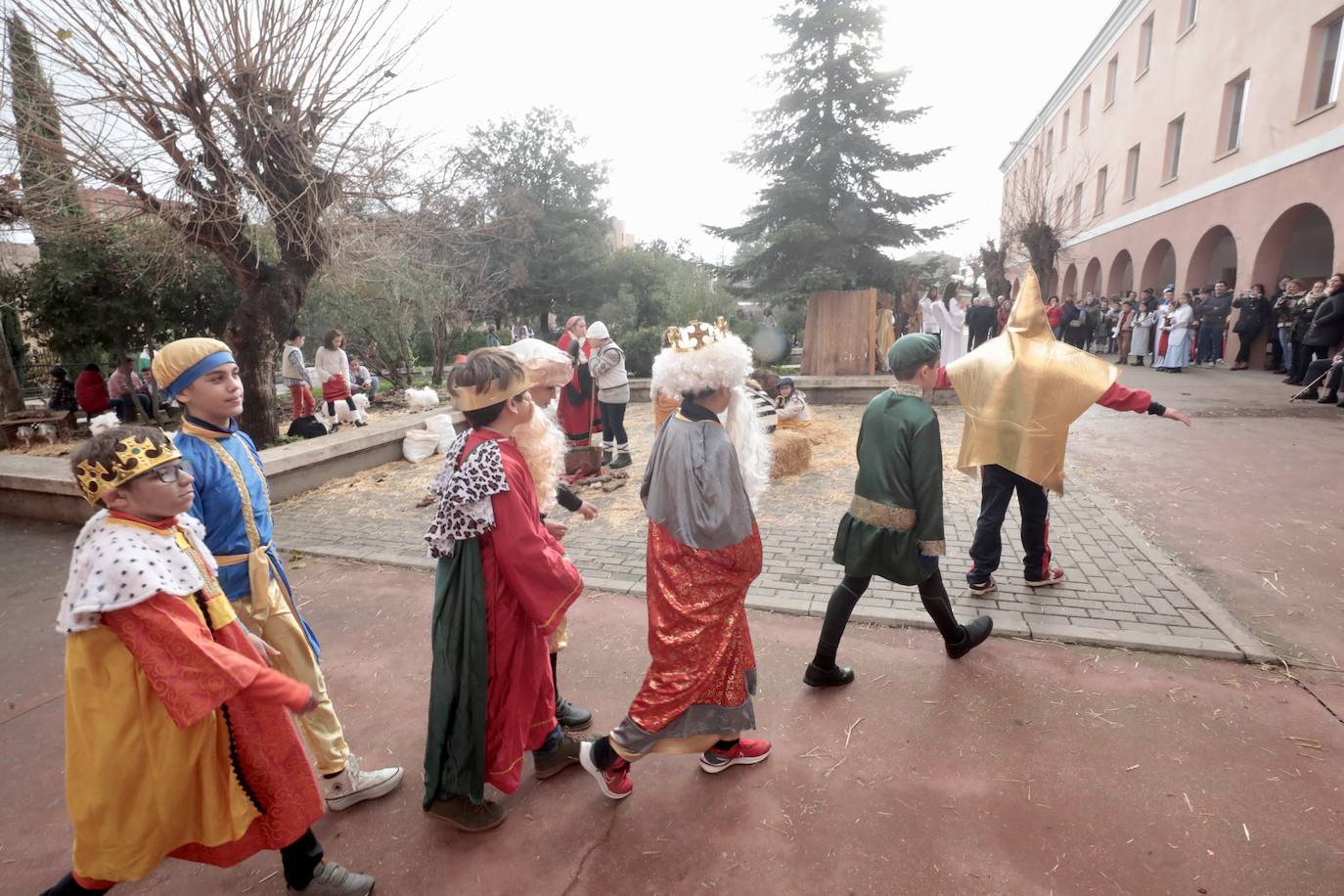 Ancianos observan a los alumnos interpretar el belén viviente.