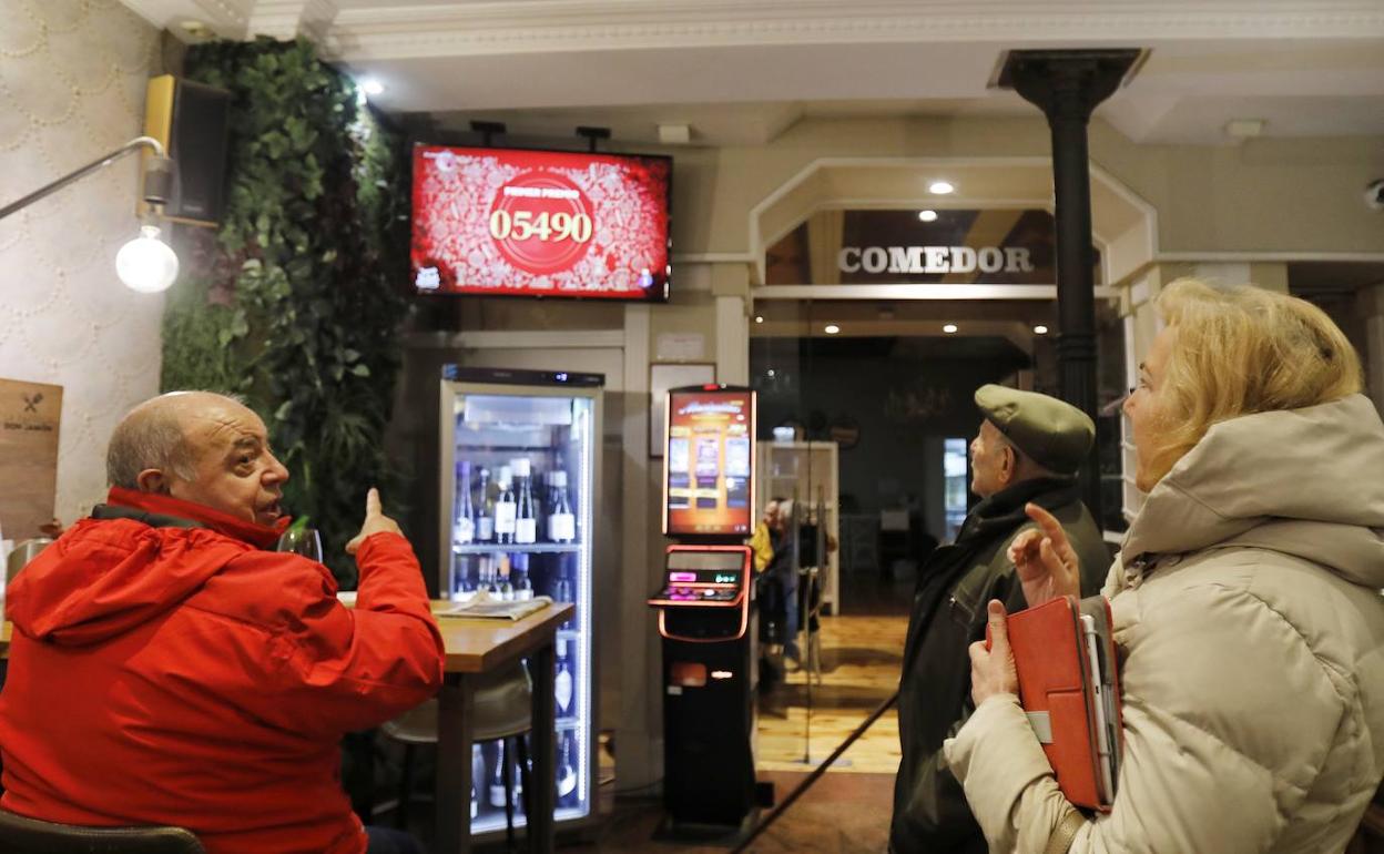 Varios clientes observan la retransmisión del sorteo, en la Parrilla de Don Jamón. 