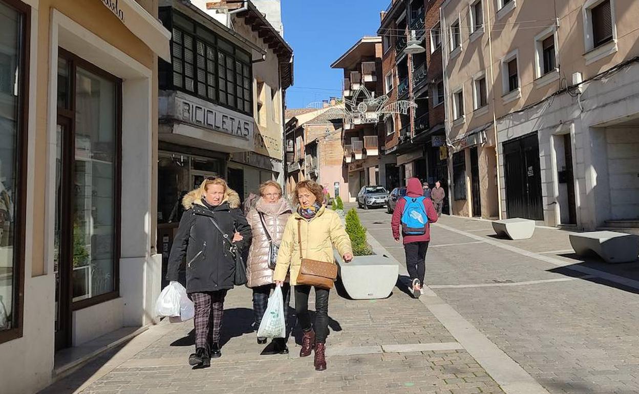 Vecinas de Cuéllar pasean por una calle comercial de la villa.