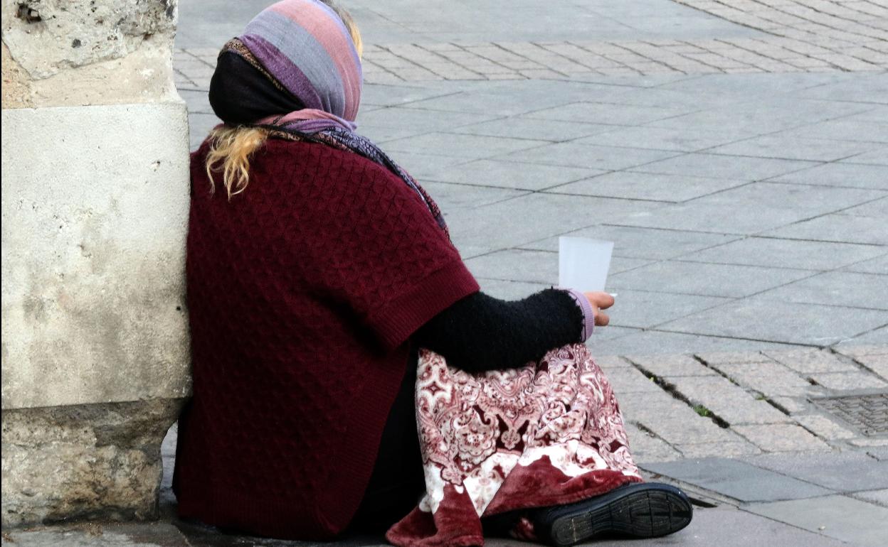 Una mujer pide limosna a las puertas de San Benito, en Valladolid. 