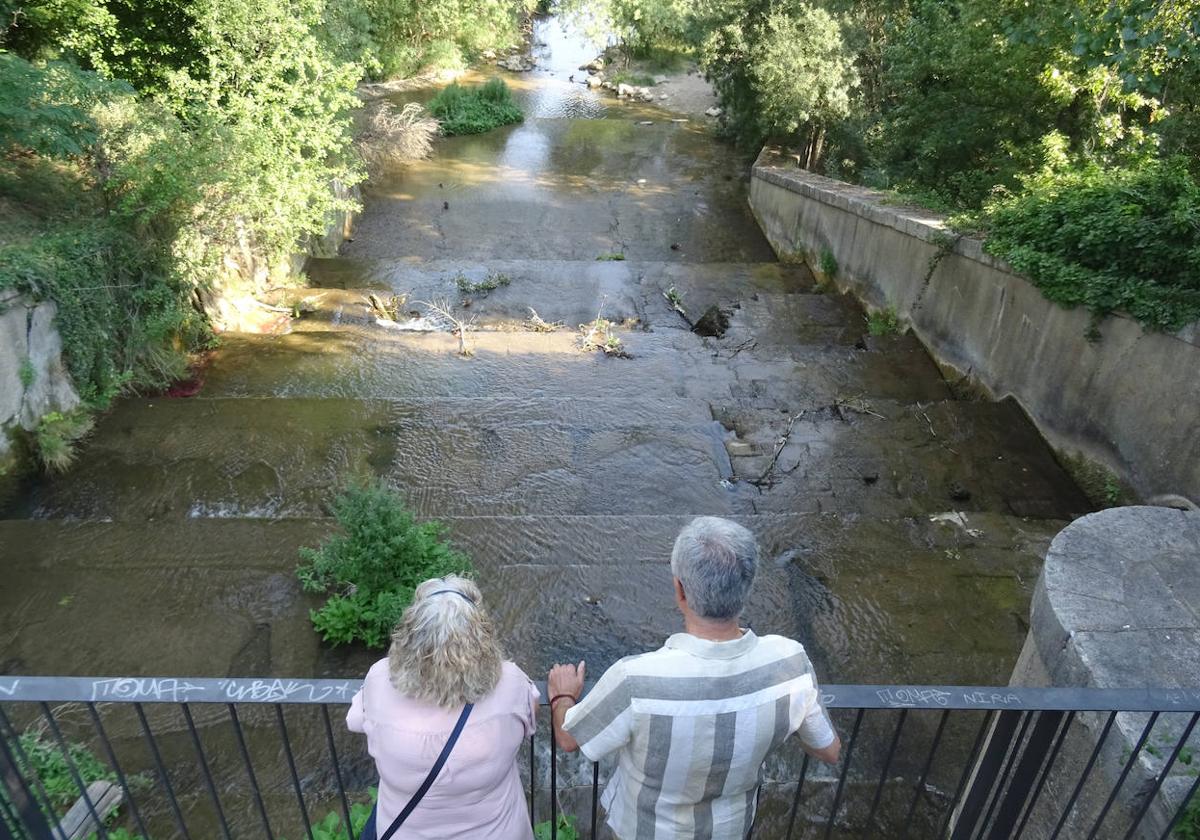 Una mujer y un hombre miran el caudal de la Esgueva, en una imagen de archivo.