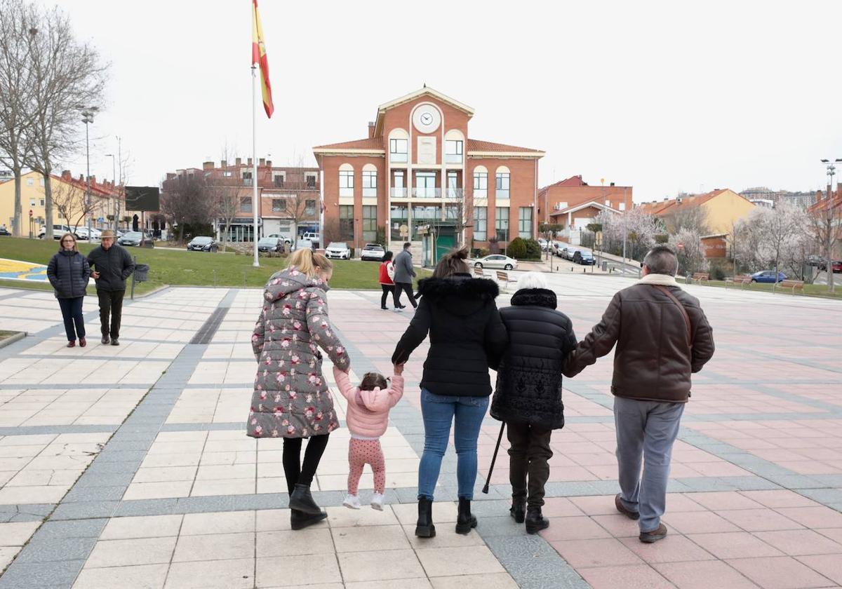 Una familia pasea por la plaza de Arroyo, frente al Ayuntamiento.