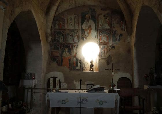 Momento en el que la luz ilumina la hornacina del altar mayor, de pinturas murales.