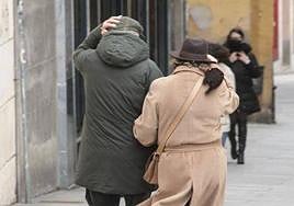 Dos viandantes se protegen del fuerte viento, en una imagen de archivo.