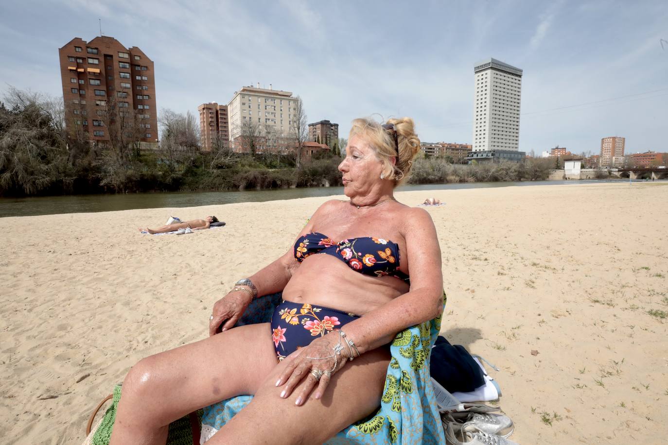 Una señora toma el sol en la playa de Moreras.