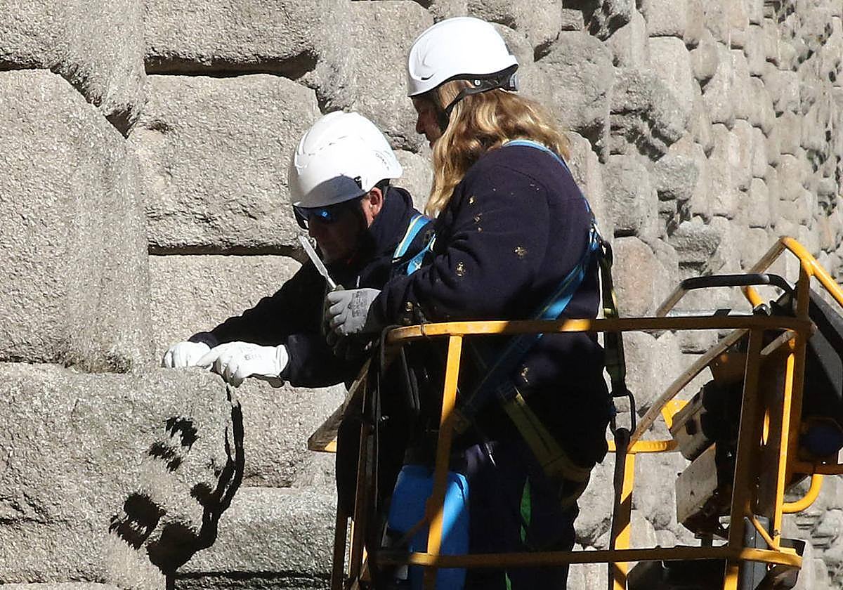 Operarios retiran vegetación del Acueducto estos días subidos en una autoescala.