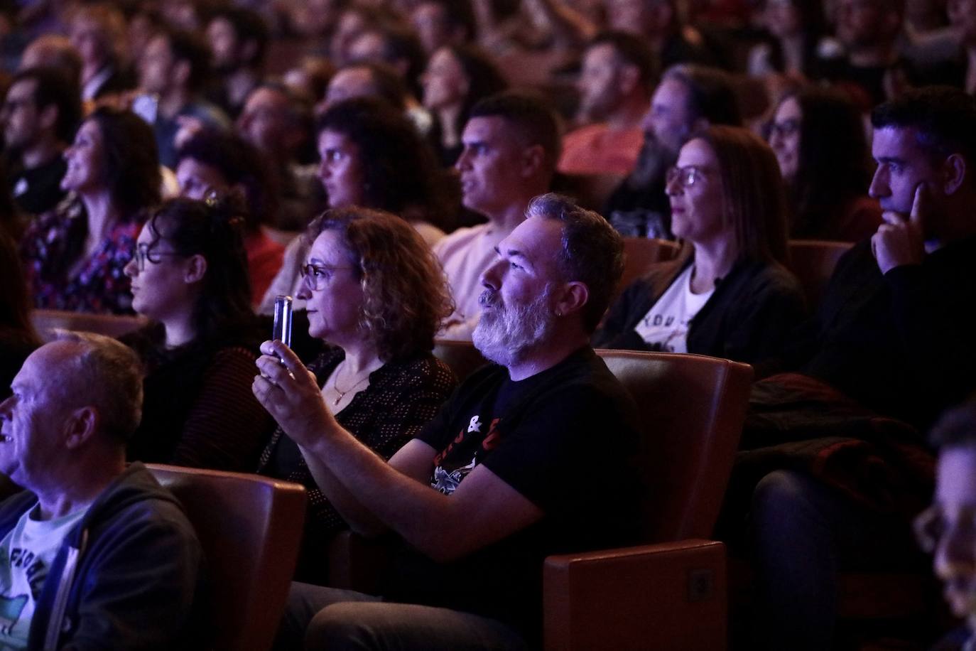 Un asistente al concierto hace una fotografía con su teléfono móvil.