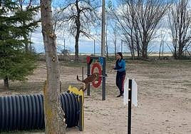 Una joven juega con su perro en el parque canino.