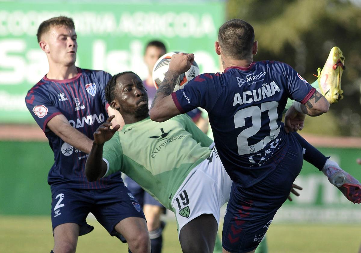 Un contrario impide a Dani Plomer llegar a un balón en el área del Villanovense.