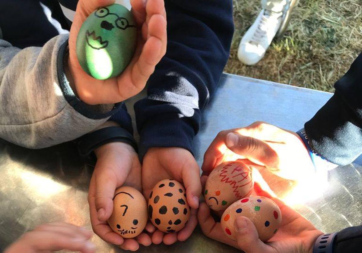 Varios niños muestran los huevos que han decorado para la ocasión.