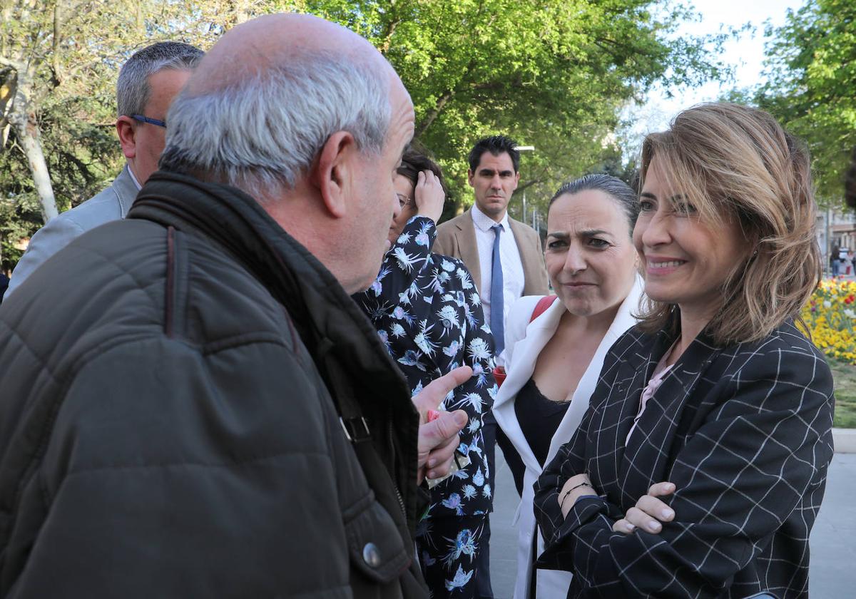 La ministra, a la derecha, y Miriam Andrés escuchan a un palentino durante su paseo por el Parque del Salón.