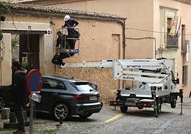 Dos operarios se disponen a disimular el cableado en la calle Capuchinos Alta, este viernes.