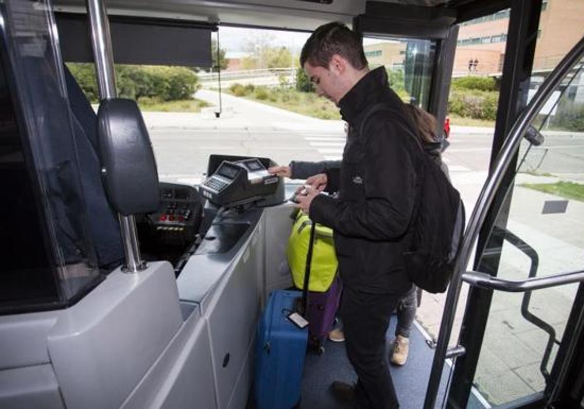 Un joven efectúa el pase de su tarjeta para poder viajar en el autobús municipal de Auvasa.