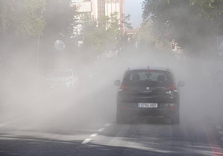 Un coche circula entre la espesa nube de polvo que ha provocado el derribo de Villa Estrella.