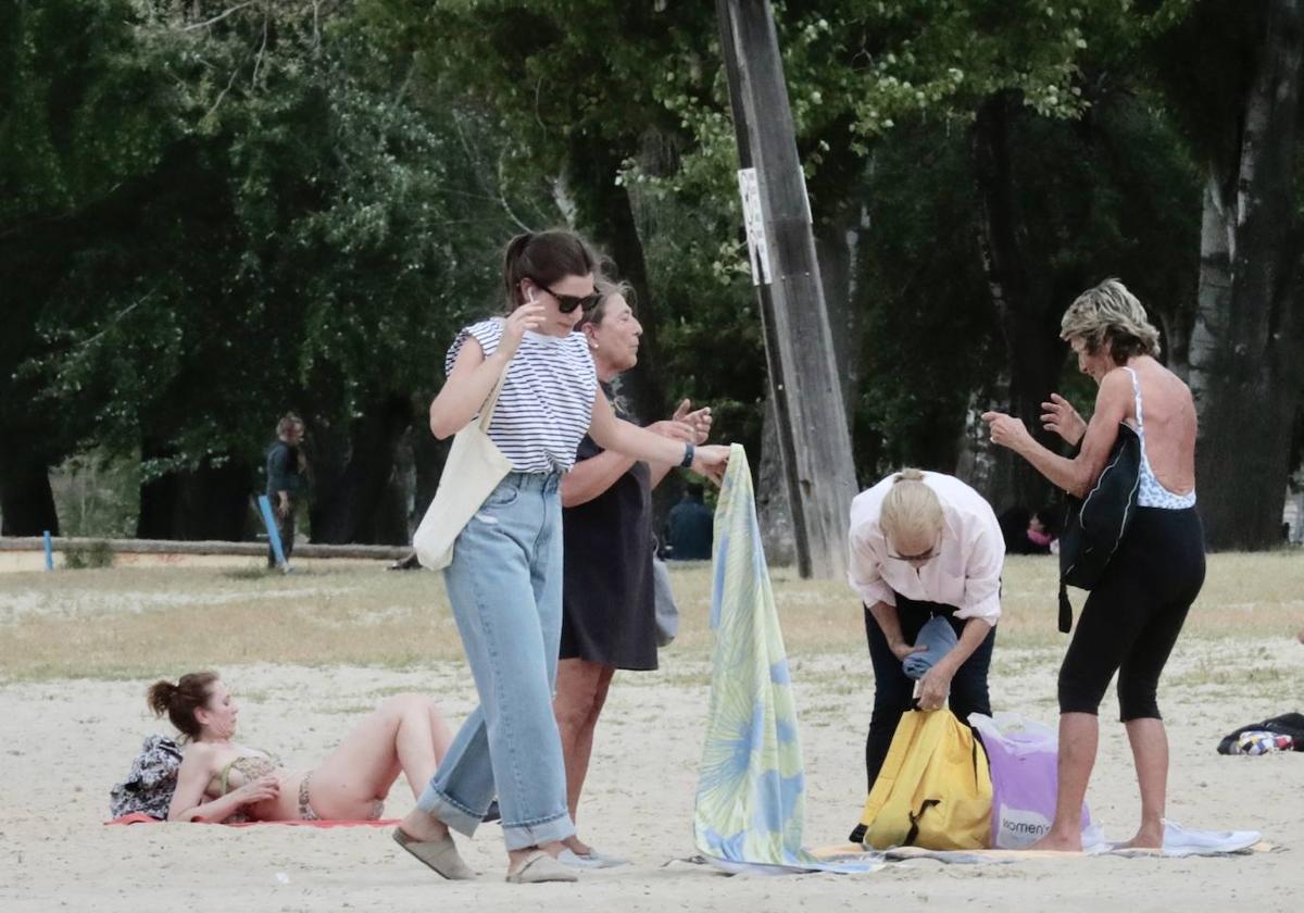 Vecinos toman el sol y pasean en la playa de las Moreras en Valladolid.