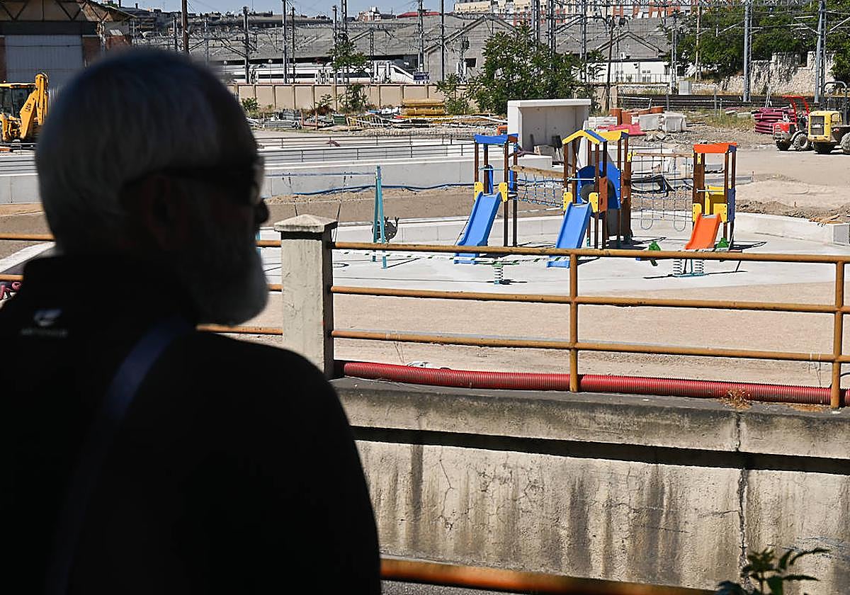Un hombre mira los nuevos columpios instalados junot al túnel de Panaderos.