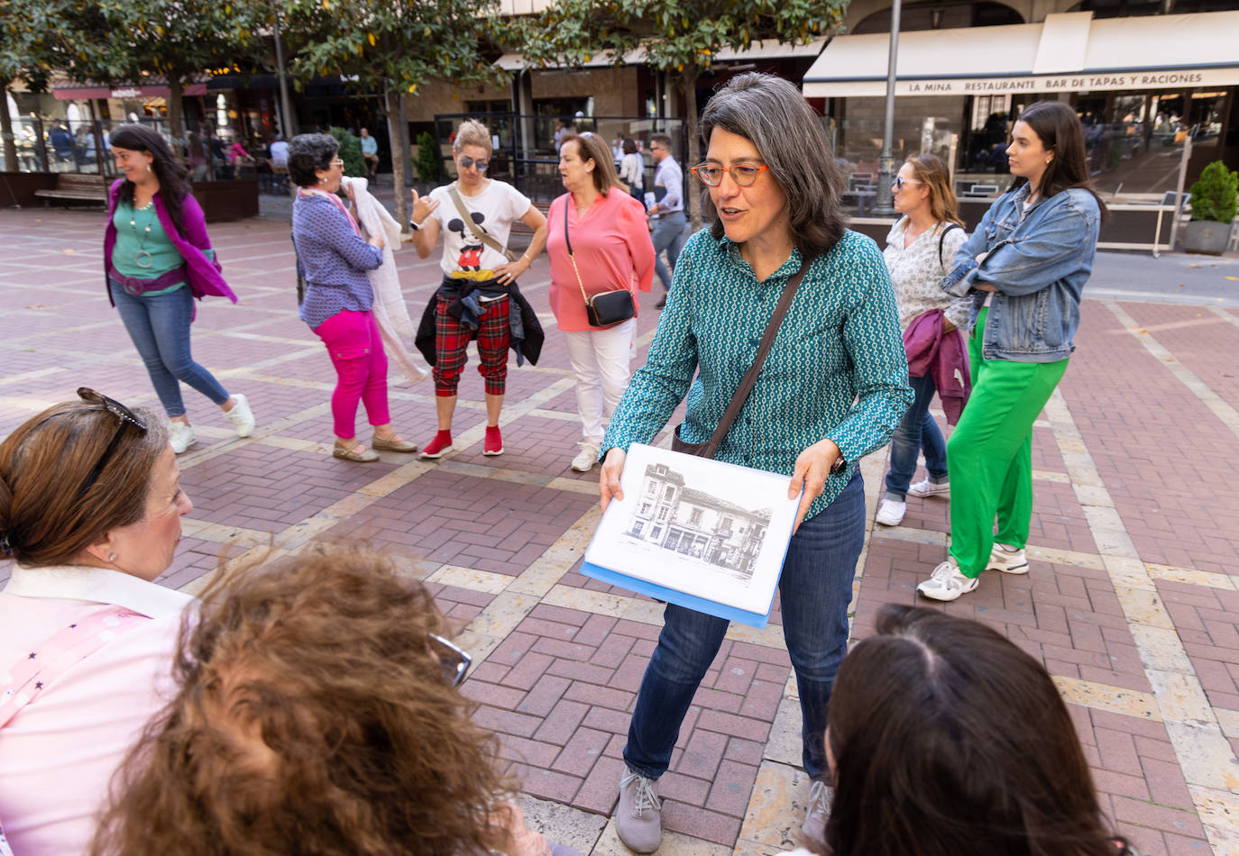 María Luisa López Municio, monitora dle taller, muestra una imagen del antiguo corral de comedias en Coca.