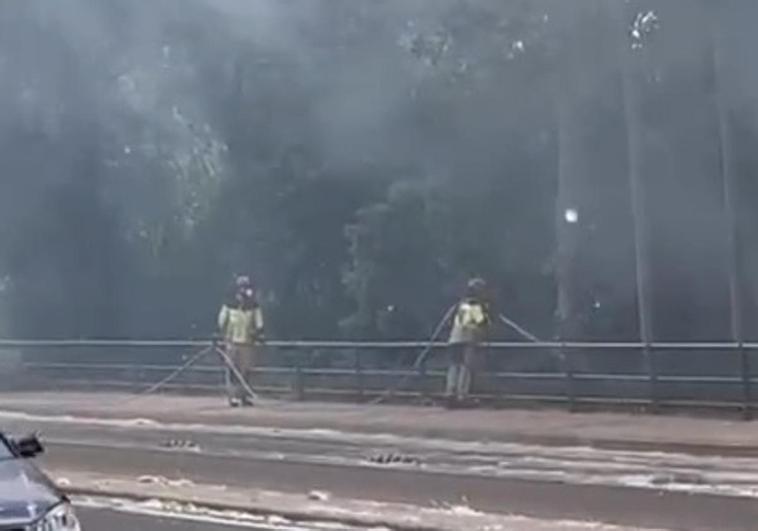 Bomberos sofocan el fuego en la avenida de Gijón.