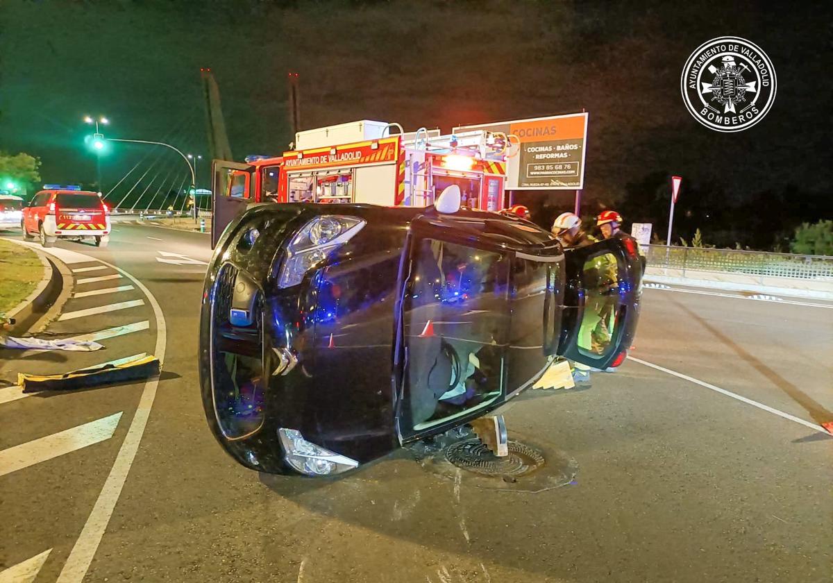 Momento en el que los bomberos sacan a uno de los pasajeros del interior del vehículo.