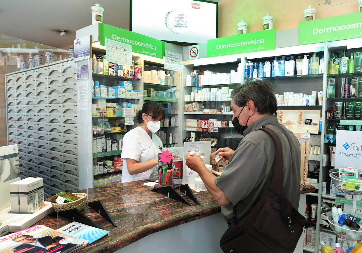 Un cliente compra en una farmacia de Palencia.