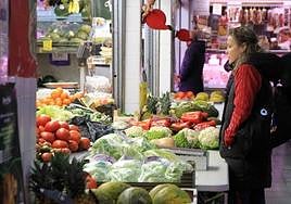 Una consumidora segoviana observa el puesto de frutas y verduras en el mercado de La Albuera.