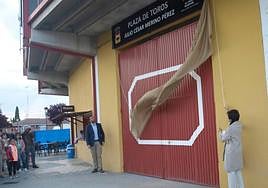La mujer y el hijo de Julio César Merino descubren el cartel que da nombre a la plaza de toros.