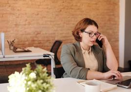 Una mujer realiza un trámite a través de su teléfono