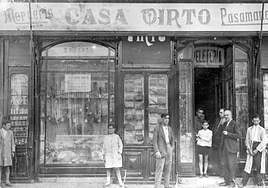 José Virto, con la mano en el bolsillo, y su padre Miguel Virto, con gafas y puro, posan ante el escaparate de Casa Virto en Duque de la Victoria en los años treinta del siglo pasado.