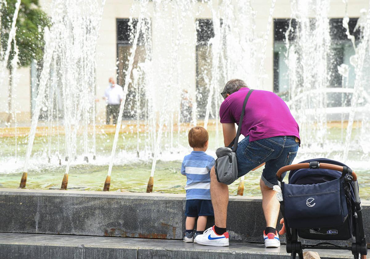 Un padre con su niño en un día de calor en la plaza Zorrilla.