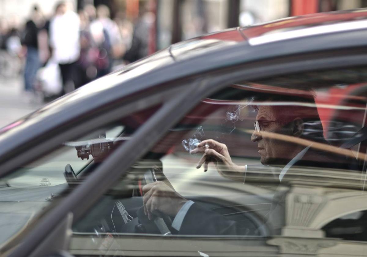 Un conductor consumiendo tabaco en un vehículo.