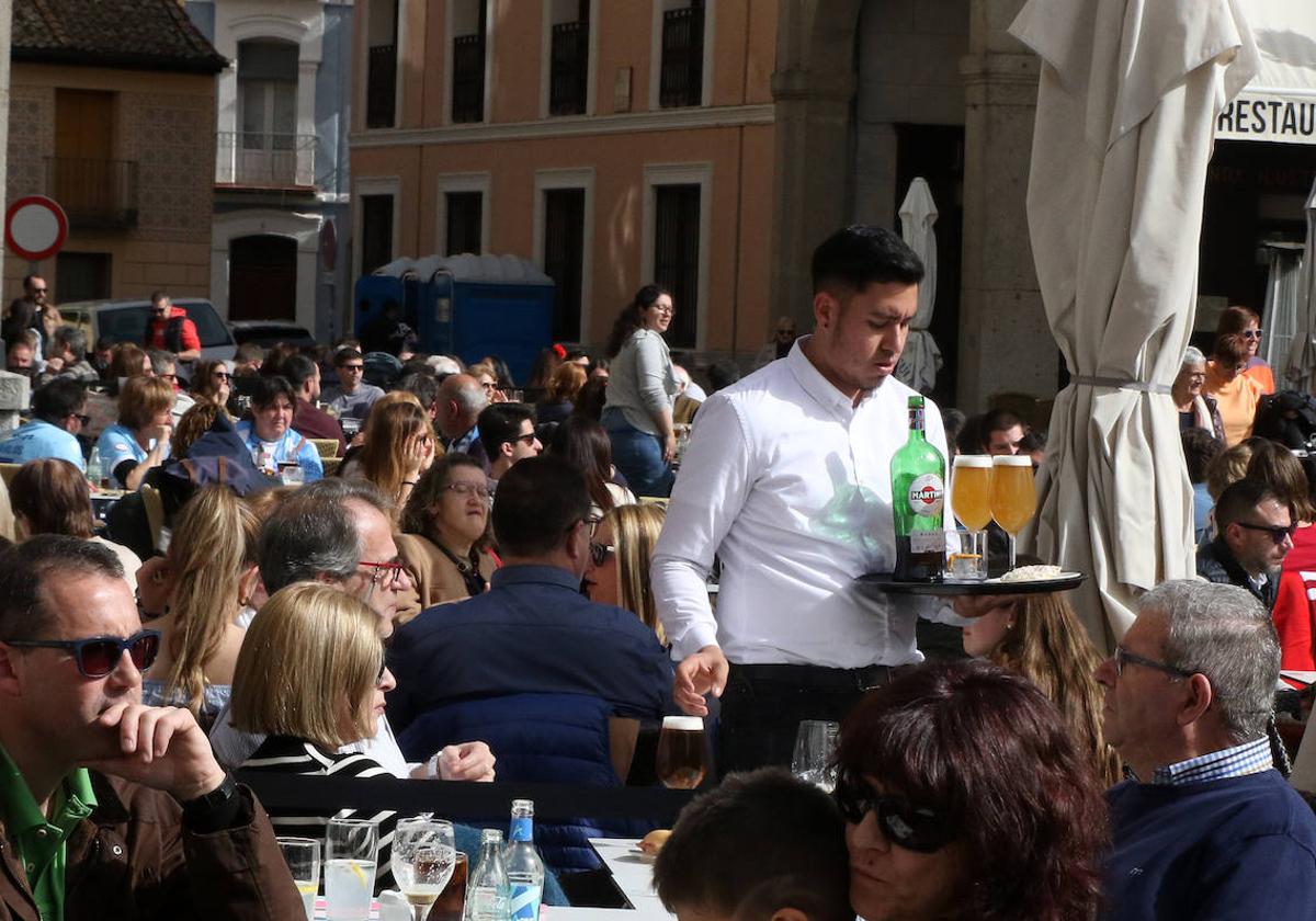 Un camarero atiende una terraza en el centro de Segovia.