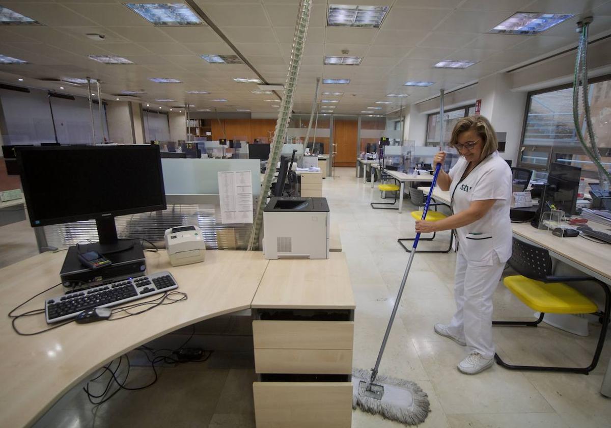 Una mujer limpia una oficinas.