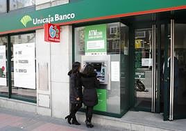 Clientes hacen gestiones en una oficina de Unicaja Banco.