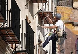 Un trabajador pinta la fachada de un edificio en una imagen de archivo.