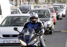 Un motorista circula entre los coches.