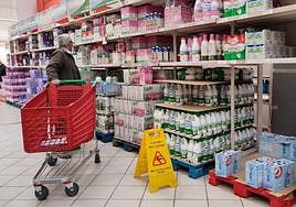 Un hombre compra leche en un supermercado.
