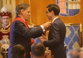 El alcalde pone medalla e insignia al líder de la oposición.