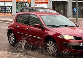 Un vehículo levanta el agua de un charco de Parquesol.