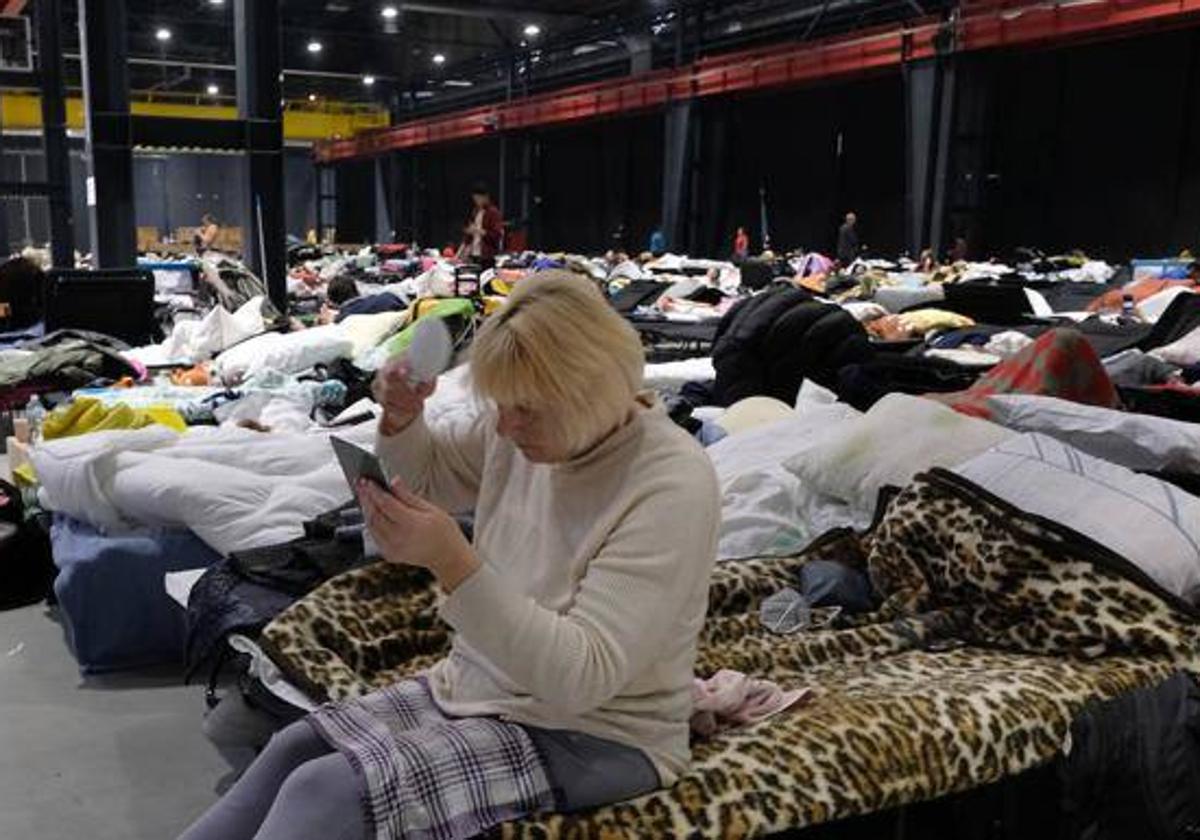 Una mujer ucraniana se peina en el campo de refugiados en la Global Expo de Varsovia.