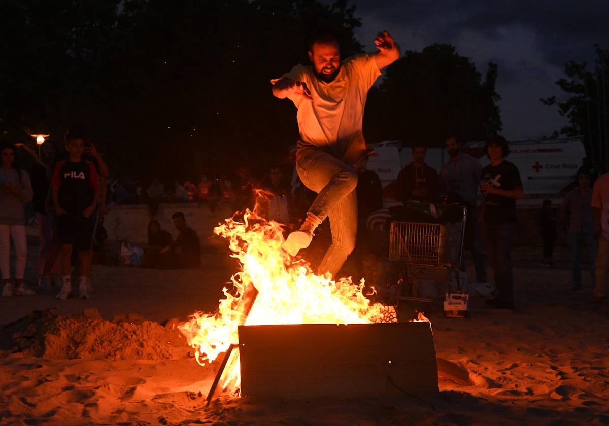 Un joven salta la hoguera en la celebración del pasado año en la playa de Las Moreras.